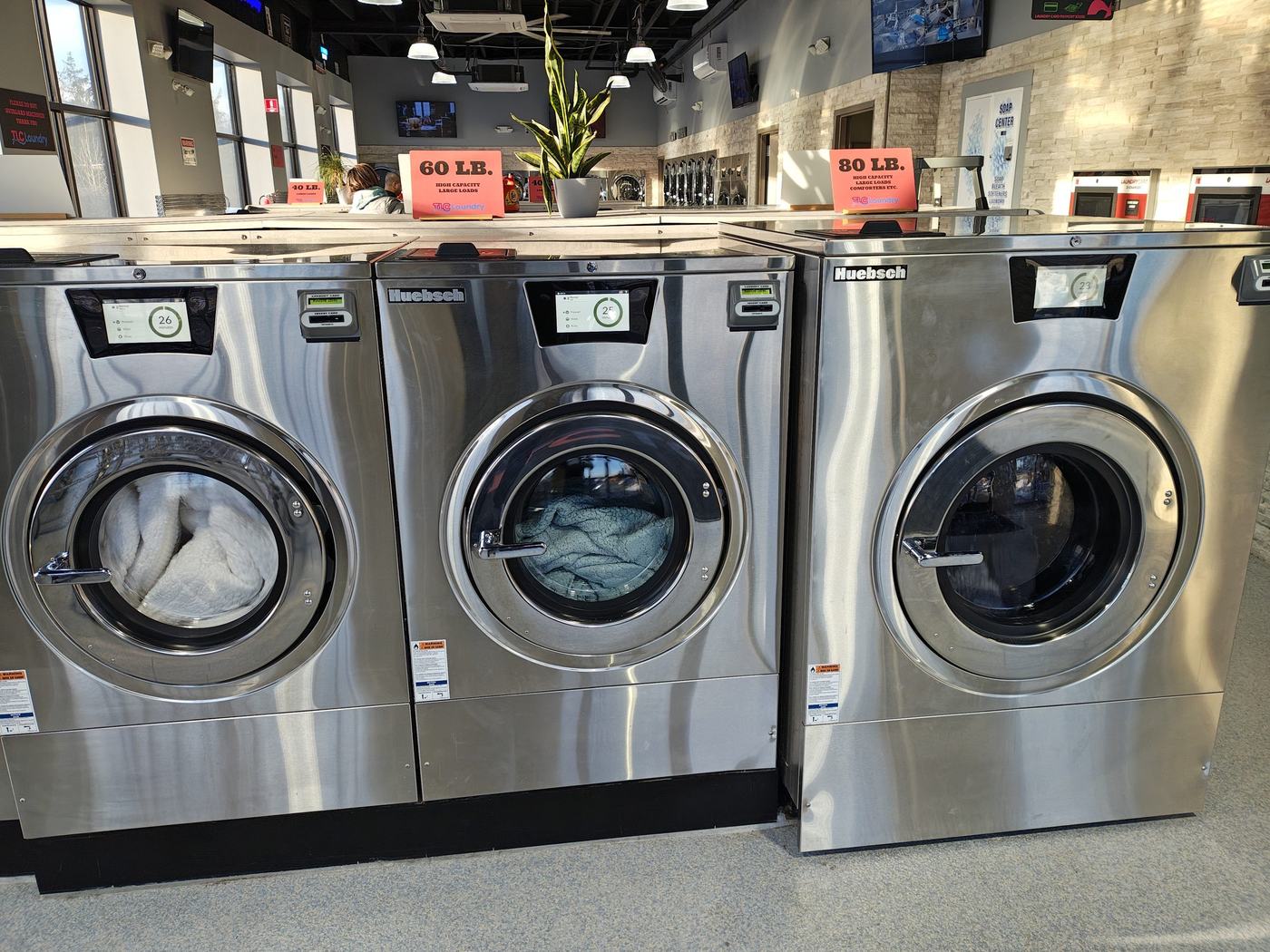 Three large 60 lb capacity front-load washers at TLC Laundry, big enough for comforters